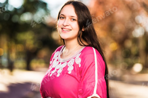 Preview: Middle eastern Moroccan happy young woman portrait outdoors. With traditional Arab dress