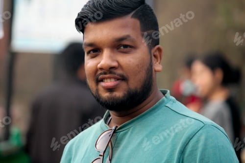 Vista previa: Indian male stands facing the camera while smiling
