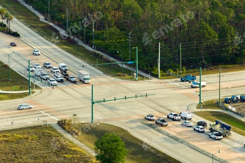 Preview: Aerial view of wide multilane road with moving cars at intersection with traffic lights.