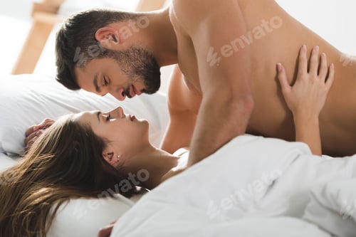 Preview: passionate young couple cuddling in bed in morning