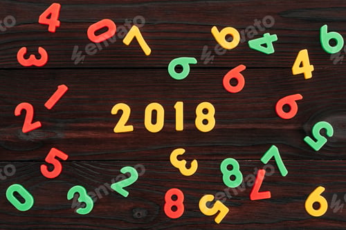 Preview: top view of colorful 2018 numbers on dark wooden surface