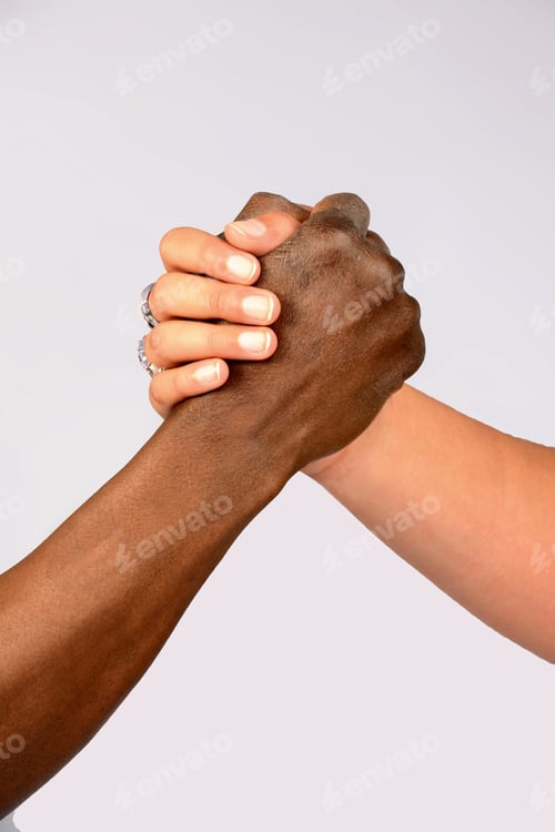 Preview: Vertical shot of two people of different races holding hands - concept of equality