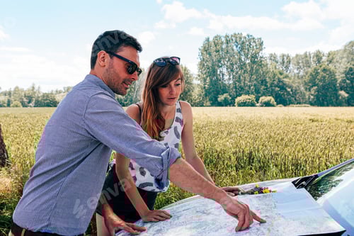 Preview: caucasian couple parked the car along the road for checking a map