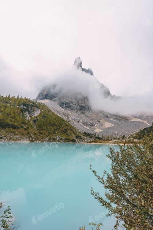 Preview: A rocky shoreline with a body of water that is blue in color lake sorapis dolomites