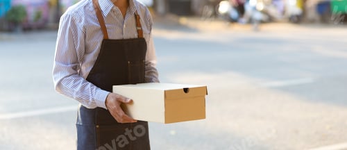 Preview: Postman or delivery man stands holding a package while waiting for customer to pick up the package.