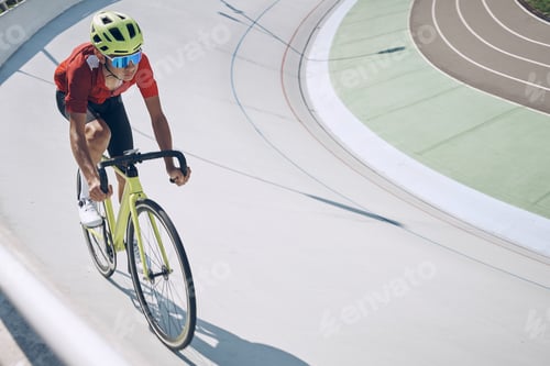 Preview: Confident man in sports clothing cycling on track outdoors