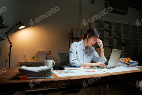 Preview: Young businesswoman suffering stress working late at night