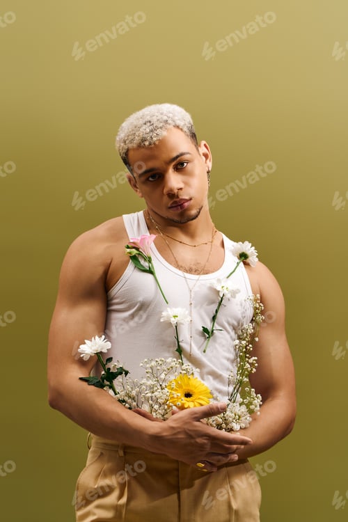 Preview: Young man with dyed hair posing with flowers in stylish studio setting