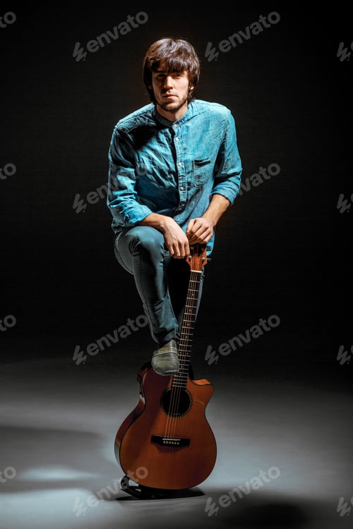 Preview: Cool Guy Standing With Guitar On Dark Background