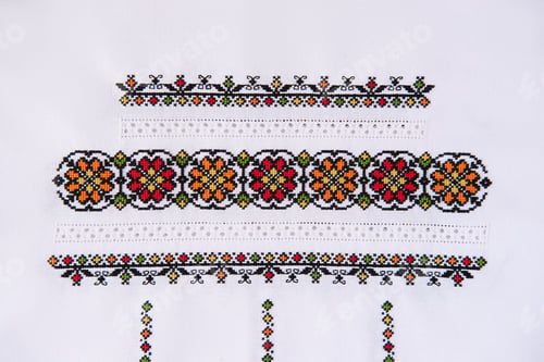 Preview: Texture of linen white fabric with embroidered element. Ukrainian embroidery pattern for folk shirt.