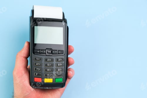 Preview: Man hand pushing a button on POS terminal with roll paper cash tape on the blue background