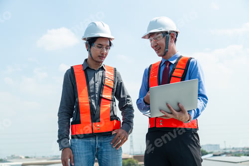 Preview: Engineers and technicians check drawings for installing solar cell panels on the roof.