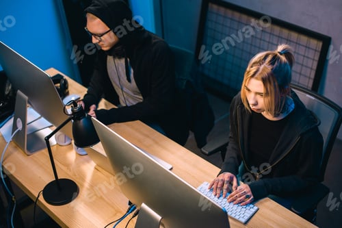 Preview: high angle view of couple of hackers working on malware