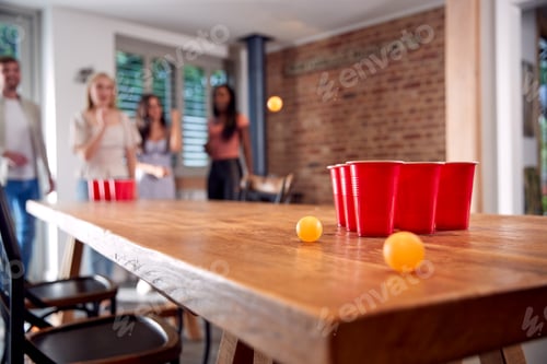 Preview: Multi-Cultural Group Of Friends Playing Game At Home Together Throwing Ball Into Plastic Cup