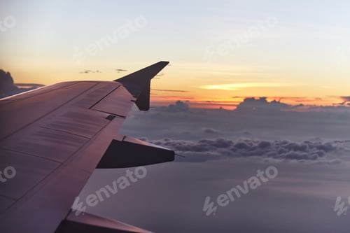 Preview: flying aircraft wing on beautiful sunset