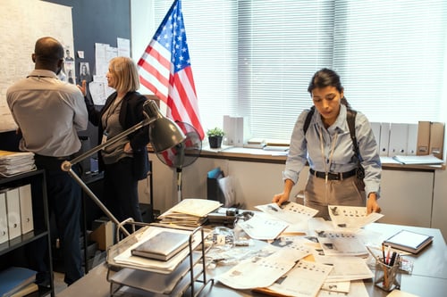 Aperçu: Young female FBI agent looking through criminal profiles of gang members