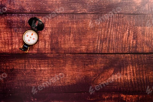 Preview: Isolated compass on a brown aged wooden table.