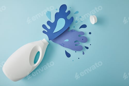 Preview: top view composition with bottle and water splashes made of paper, on blue