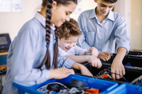 Preview: Group of kids choose parts of robotic toys for building robots at school lesson