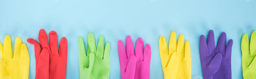 Preview: panoramic shot of multicolored rubber gloves in row on blue background