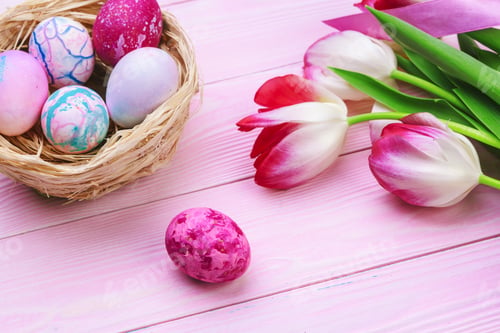 Preview: Easter background with colorful eggs and tulips over pink wood. Top view with copy space