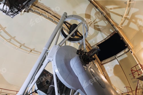 Preview: Astronomer admiring massive telescope inside observatory building on a clear night