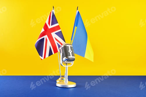 Preview: Microphone on a background of a blurry flags Ukraine and Great Britain. European Song Contest