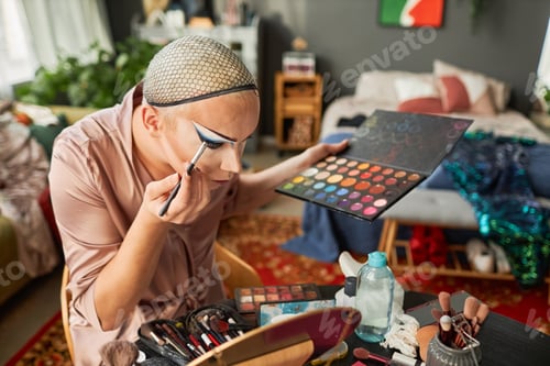 Preview: Man Doing Makeup in Messy Hotel Room and Looking in Mirror