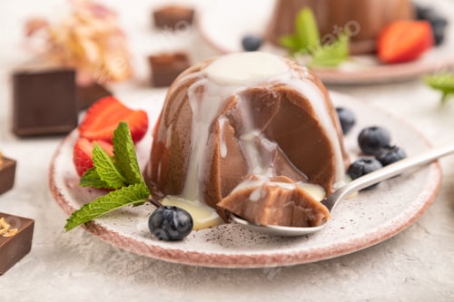 Preview: Chocolate jelly with strawberry, blueberry and milk cream sliced with spoon on gray concrete
