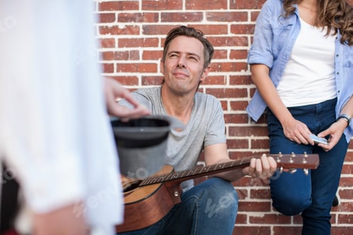 Preview: Pedestrian putting money in street musician's hat, mid section