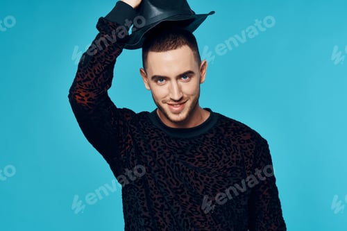 Preview: man in black sweater caps posing fashion studio blue background