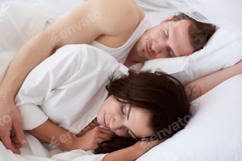 Preview: Young couple asleep in bed