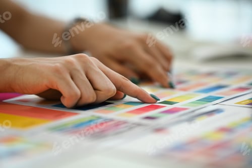 Preview: Closeup view female graphic designer choosing color samples for design project at modern office