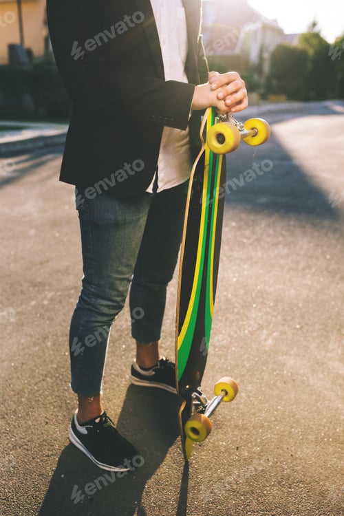 Preview: Image of a man with longboard going on road