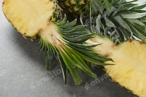 Preview: halves of ripe yellow pineapple on grey background