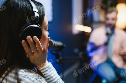 Preview: Side view of successful woman hosting podcast interviewing man while recording