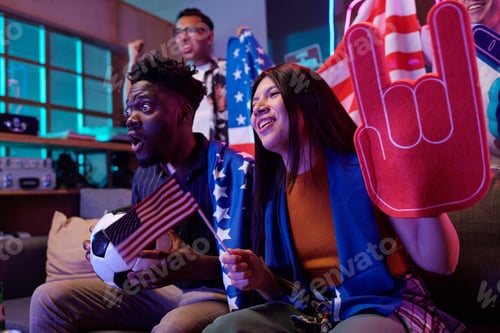 Preview: Young Black Man and Young Asian Woman Cheering While Watching Soccer Match