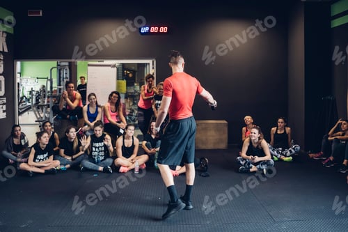 Preview: Group of women training in gym, listening to male trainer