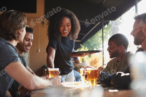Preview: Waitress Serving Drinks To Group Of Male Friends Meeting In Sports Bar