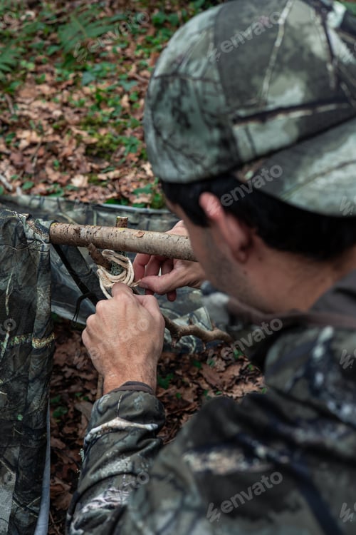 Preview: vertical portrait from behind Building Shelter: Explorer Tying Poles in Nature