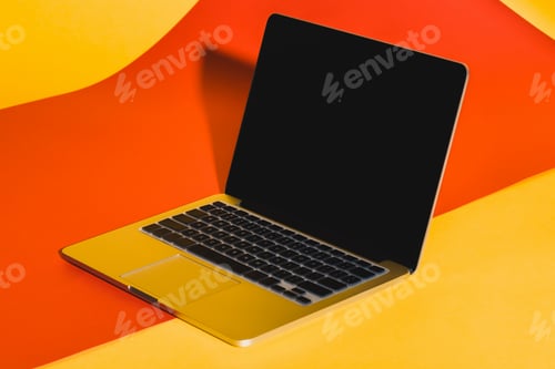 Preview: opened laptop with blank screen on yellow and red background