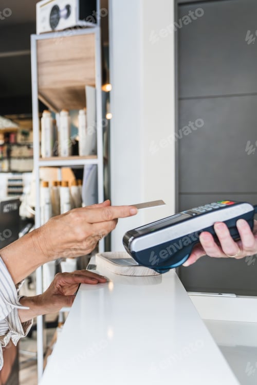 Preview: Customer making contactless credit card payment at salon counter