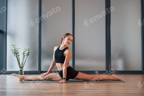Preview: Good stretching. Young woman in sportive wear and with slim body have fitness yoga day indoors