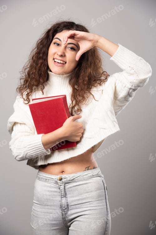 Preview: Smiling Woman Holding a Red Book and Posing