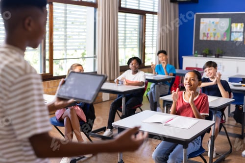 Preview: Presenting project on tablet, student engaging classmates in school activity