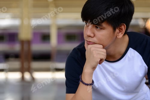 Preview: Young handsome Asian tourist man at the railway station
