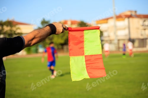 Preview: Soccer (football) referee assistant with flag on the field