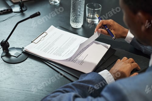 Preview: Middle Aged Black Man Reviewing Documents during Political Meeting at Desk