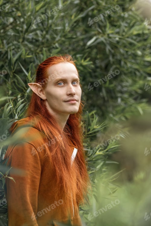 Preview: Artistic elf man with red hair and green eyes in the forest