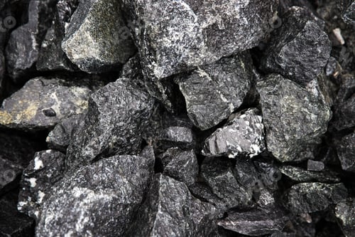 Preview: Wet natural black fragments of stones with interspersed marbles, top view